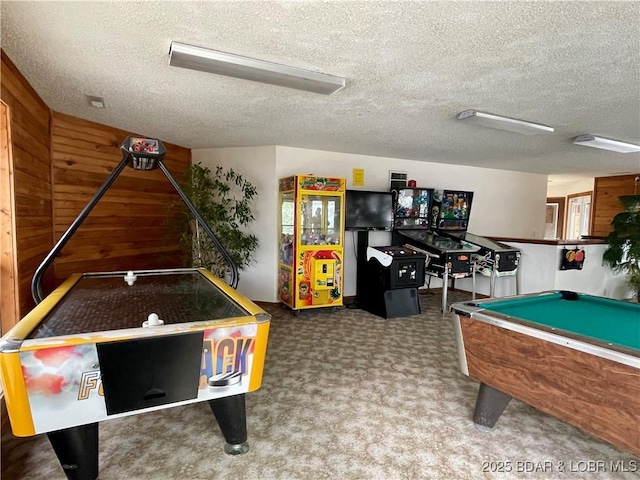 playroom featuring a textured ceiling, pool table, and wood walls