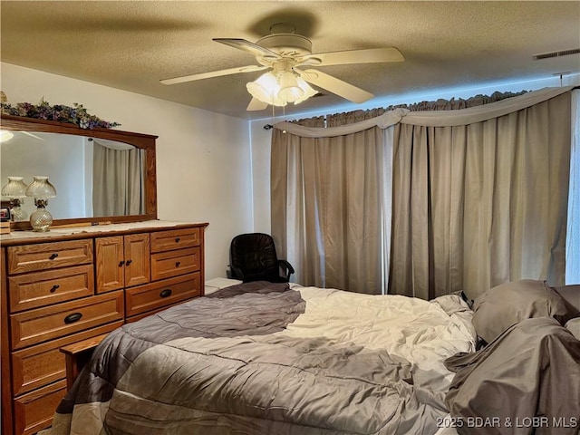 bedroom with a textured ceiling and ceiling fan