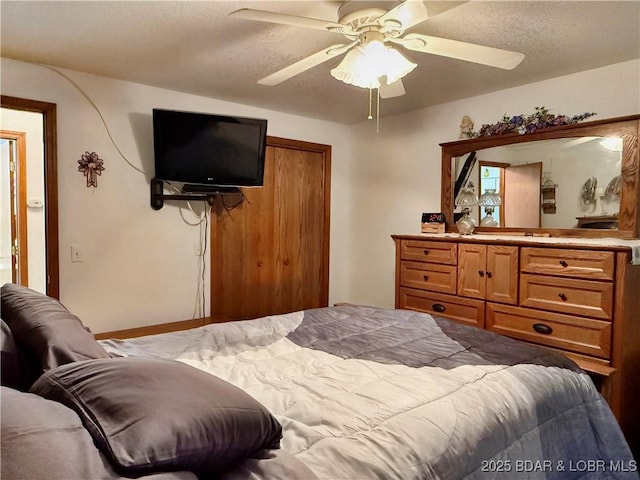 bedroom featuring ceiling fan and a textured ceiling