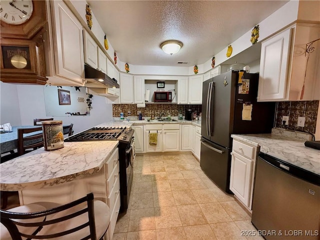 kitchen with white cabinets, dishwasher, black gas range oven, sink, and a breakfast bar