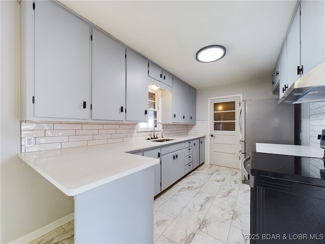 kitchen with sink, kitchen peninsula, electric range oven, and tasteful backsplash