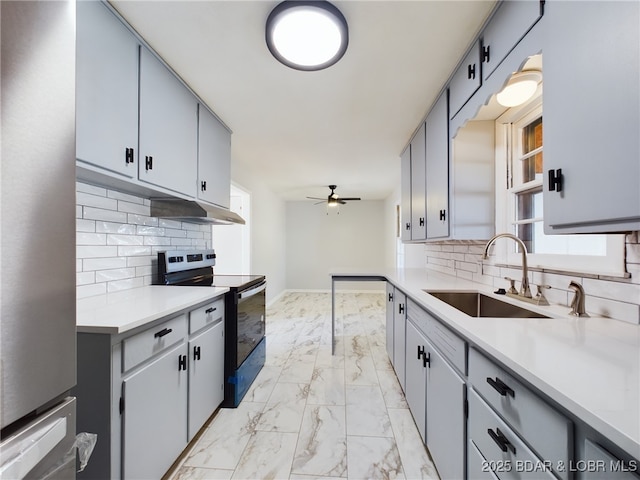 kitchen featuring sink, black range with electric stovetop, ceiling fan, and tasteful backsplash