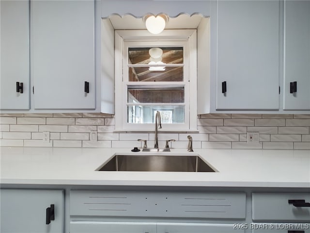 kitchen with sink, white cabinets, and decorative backsplash