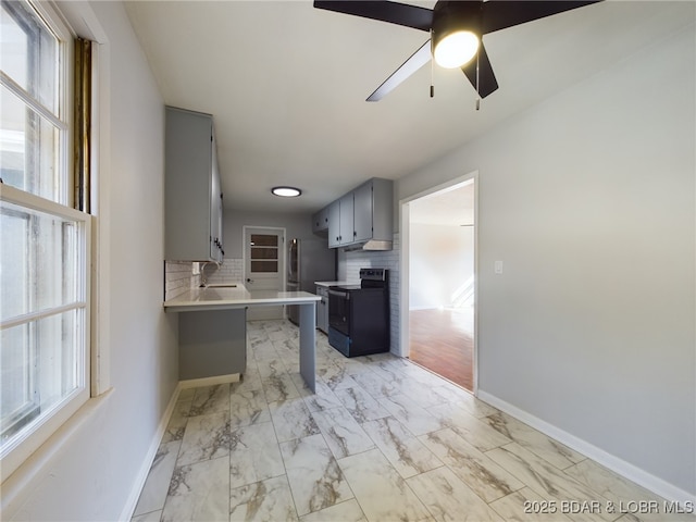 kitchen with kitchen peninsula, black electric range oven, ceiling fan, tasteful backsplash, and a kitchen bar