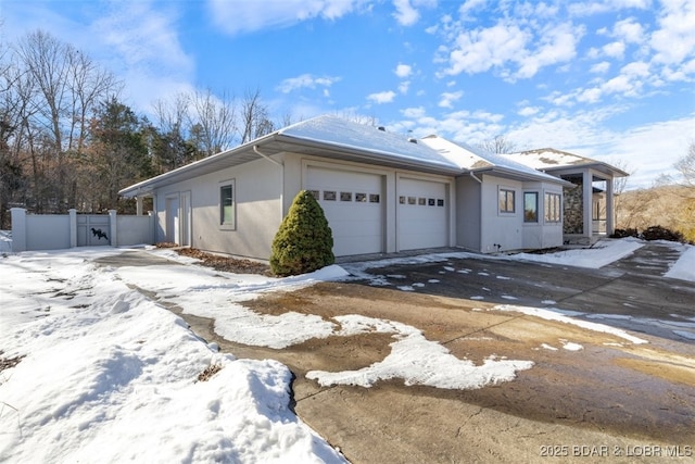 snow covered property with a garage