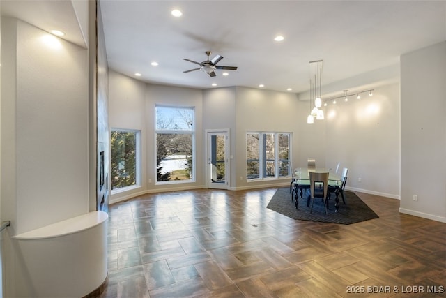 unfurnished dining area with ceiling fan and dark parquet floors