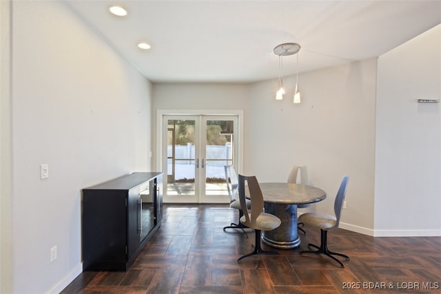 dining space with dark parquet flooring and french doors