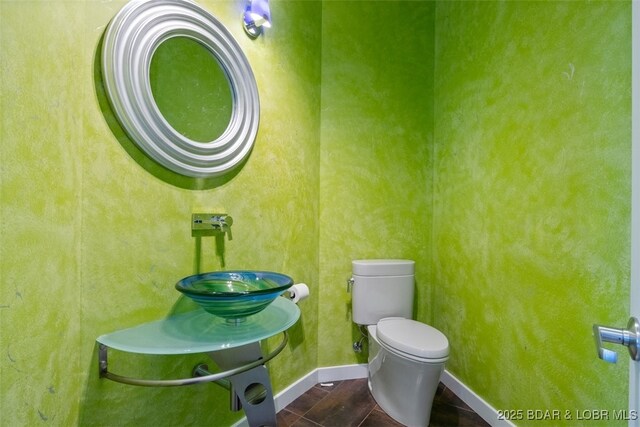 bathroom featuring sink, toilet, and tile patterned flooring