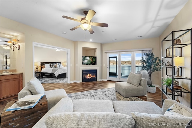 living room featuring hardwood / wood-style floors, sink, and ceiling fan