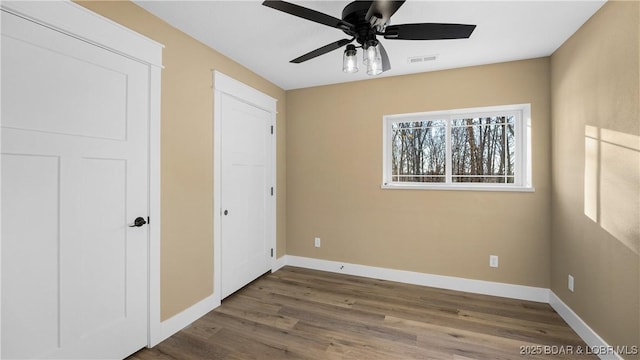 unfurnished bedroom featuring wood-type flooring and ceiling fan