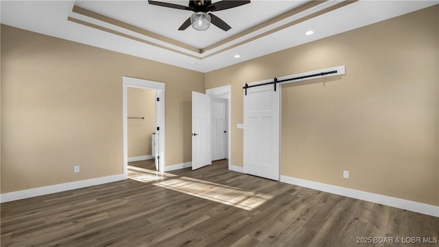 20 Simple Time Dr, Camdenton, MO 65020 - unfurnished bedroom with a raised ceiling, wood finished floors, a barn door, recessed lighting, and ensuite bath