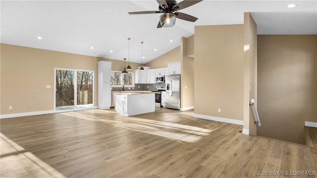 unfurnished living room with ceiling fan, light hardwood / wood-style flooring, and high vaulted ceiling