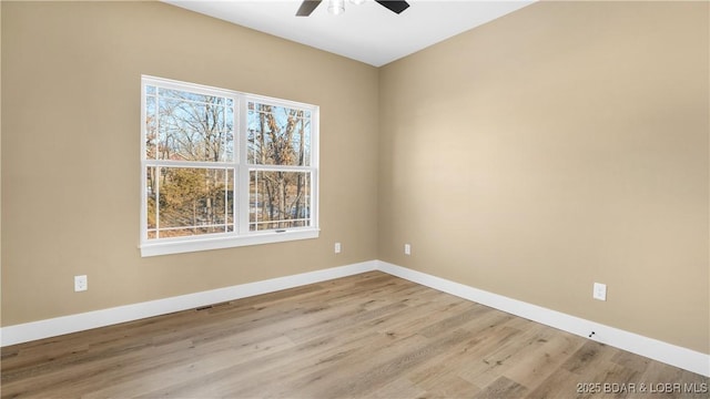 empty room with ceiling fan and light hardwood / wood-style flooring