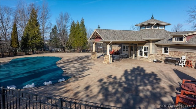 20 Simple Time Dr, Camdenton, MO 65020 - back of property featuring a patio, fence, stone siding, and roof with shingles