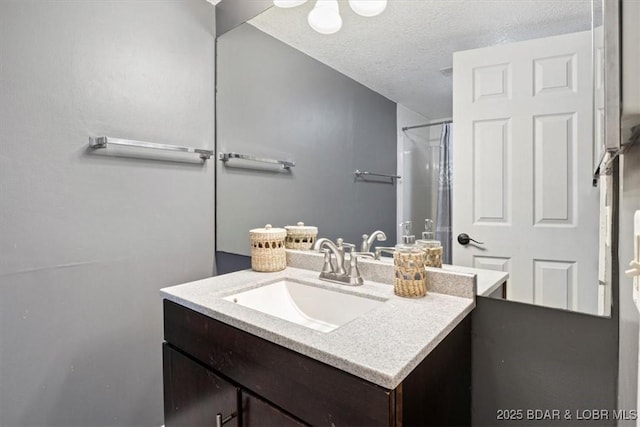 bathroom featuring a textured ceiling, a shower, and vanity