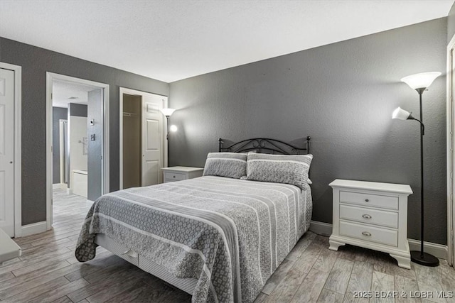 bedroom with light hardwood / wood-style flooring and ensuite bathroom