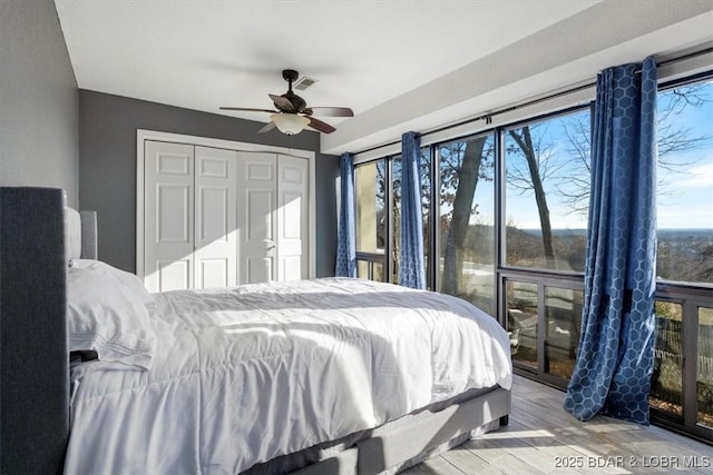 bedroom featuring a closet, ceiling fan, and light hardwood / wood-style flooring