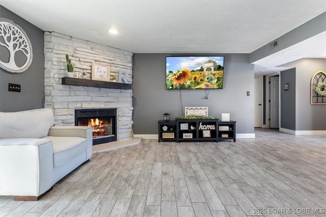 living room featuring light hardwood / wood-style flooring and a fireplace