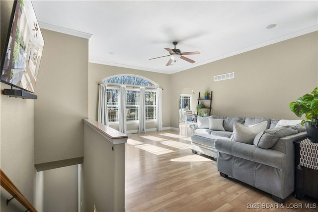 living room featuring light hardwood / wood-style flooring, ceiling fan, and ornamental molding