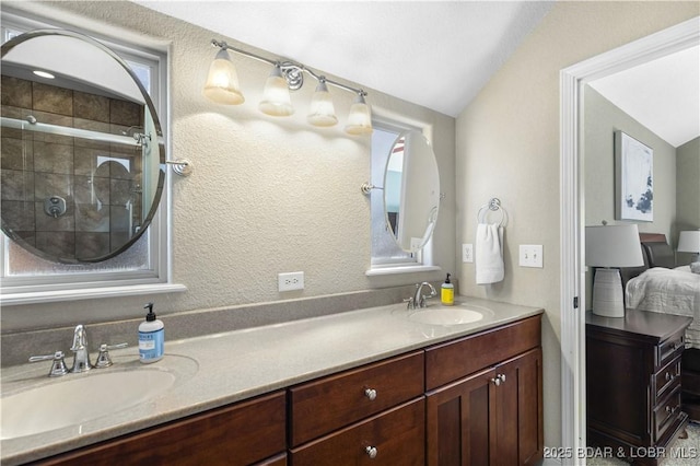 bathroom featuring an enclosed shower, vanity, and vaulted ceiling