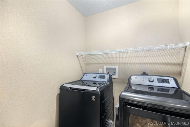 laundry area with a textured ceiling and washer and clothes dryer