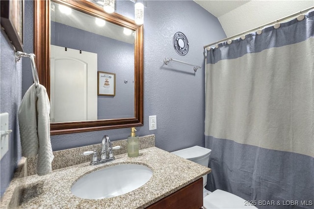 bathroom with toilet, vanity, a shower with curtain, and vaulted ceiling