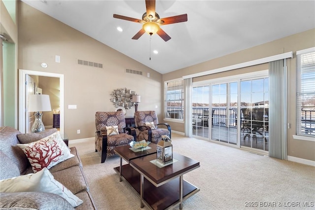 living room featuring ceiling fan, high vaulted ceiling, and light carpet