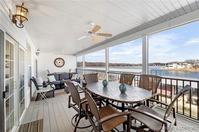 sunroom / solarium featuring ceiling fan, plenty of natural light, and a water view