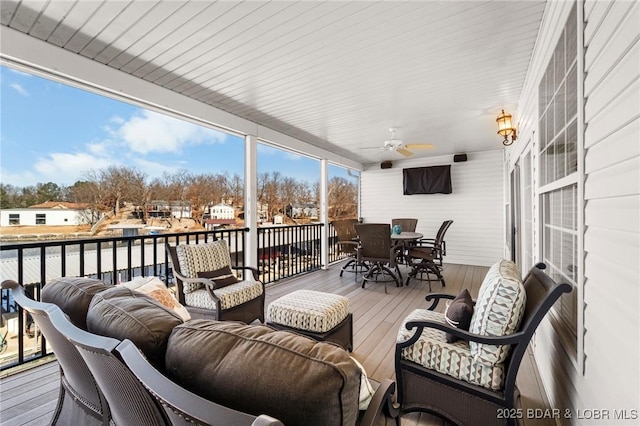 wooden terrace with an outdoor living space and ceiling fan