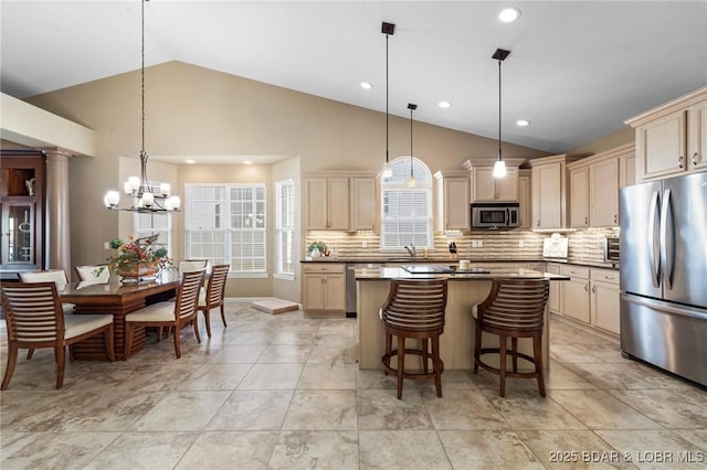 kitchen featuring a center island, decorative light fixtures, stainless steel appliances, tasteful backsplash, and sink