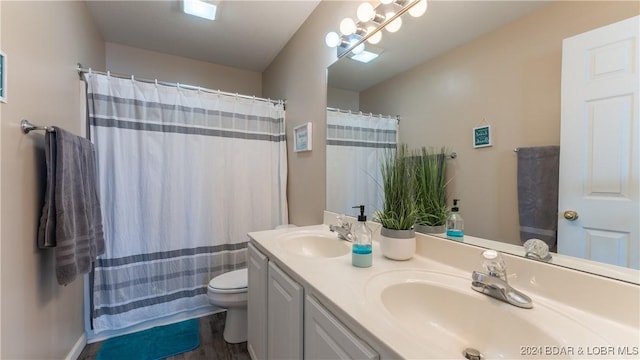 bathroom with vanity, hardwood / wood-style flooring, toilet, and walk in shower