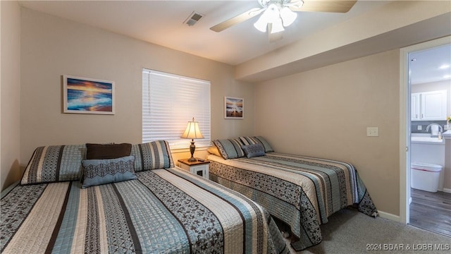 carpeted bedroom with ceiling fan, connected bathroom, and sink