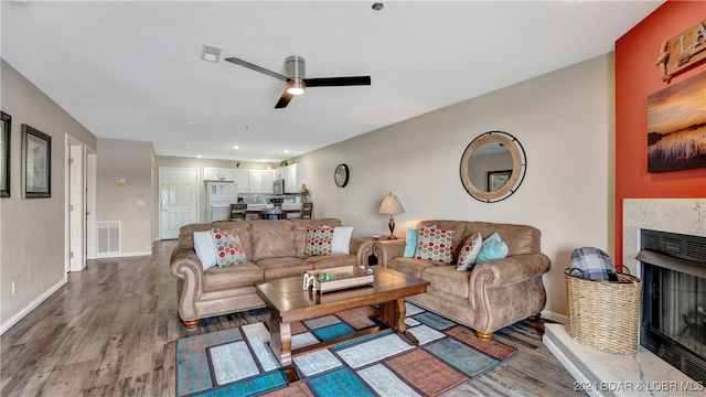 living room featuring wood-type flooring and ceiling fan