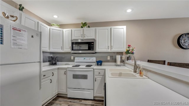 kitchen with sink, white appliances, white cabinets, and backsplash