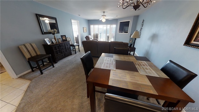 dining space featuring ceiling fan with notable chandelier and light carpet