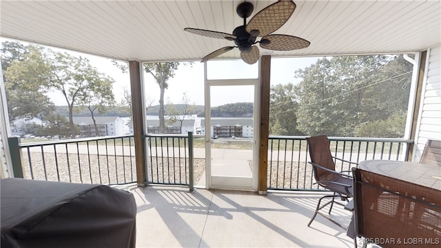 sunroom / solarium featuring ceiling fan and a water view