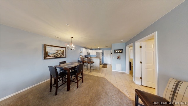 dining area featuring light tile patterned flooring and an inviting chandelier