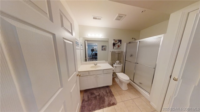 bathroom with vanity, toilet, a shower with shower door, and tile patterned flooring