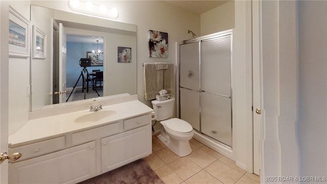 bathroom featuring an enclosed shower, vanity, tile patterned floors, and toilet