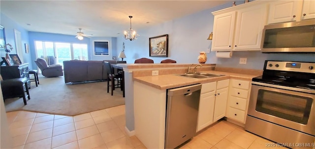 kitchen featuring white cabinetry, appliances with stainless steel finishes, kitchen peninsula, and hanging light fixtures