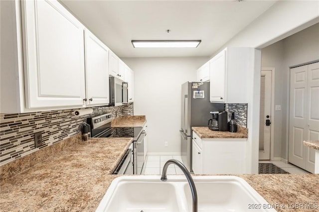 kitchen with sink, white cabinetry, tasteful backsplash, light tile patterned floors, and stainless steel appliances