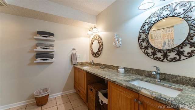 bathroom with tile patterned flooring, vanity, and a textured ceiling