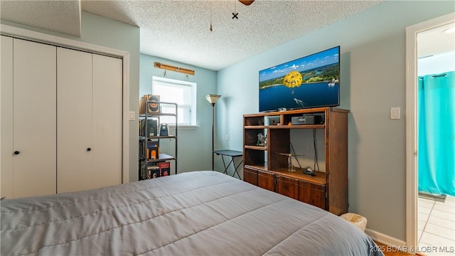 bedroom with ceiling fan, a closet, and a textured ceiling