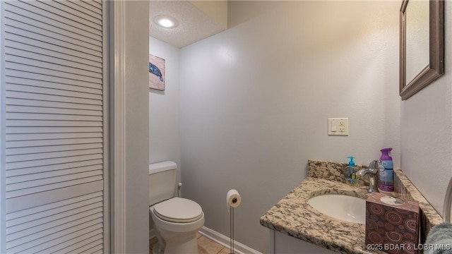 bathroom with vanity, a textured ceiling, and toilet