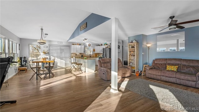 living room featuring dark hardwood / wood-style flooring, lofted ceiling, and ceiling fan