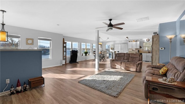 living room with ceiling fan, a healthy amount of sunlight, sink, and hardwood / wood-style floors