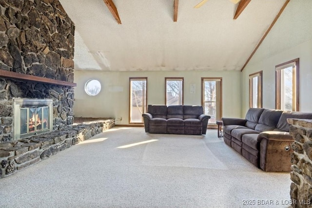 living room featuring a stone fireplace, plenty of natural light, lofted ceiling with beams, and a textured ceiling