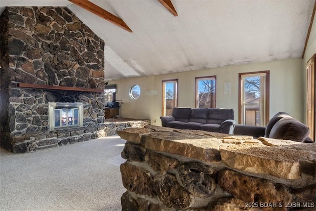 living room featuring a stone fireplace, carpet floors, lofted ceiling with beams, and a textured ceiling