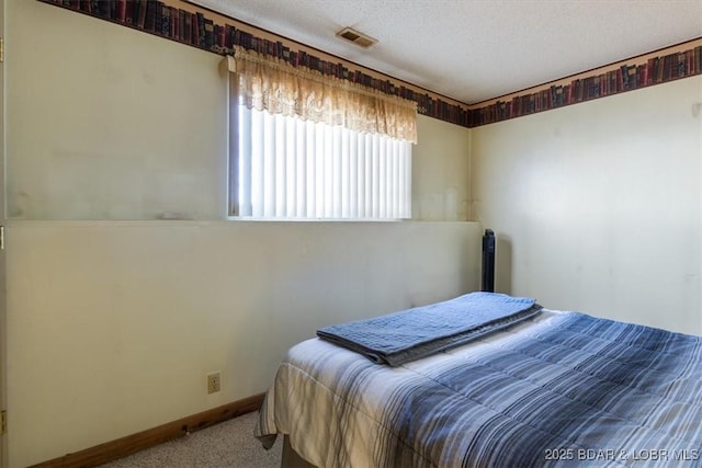 bedroom featuring carpet flooring and a textured ceiling