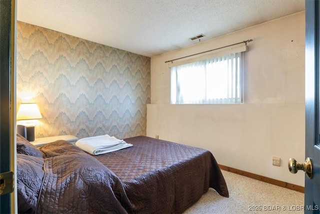 bedroom featuring light carpet and a textured ceiling